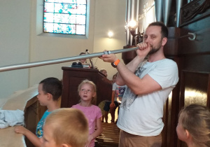 pan od rytmiki i dzieci stoją przy organach na chórze w kościele